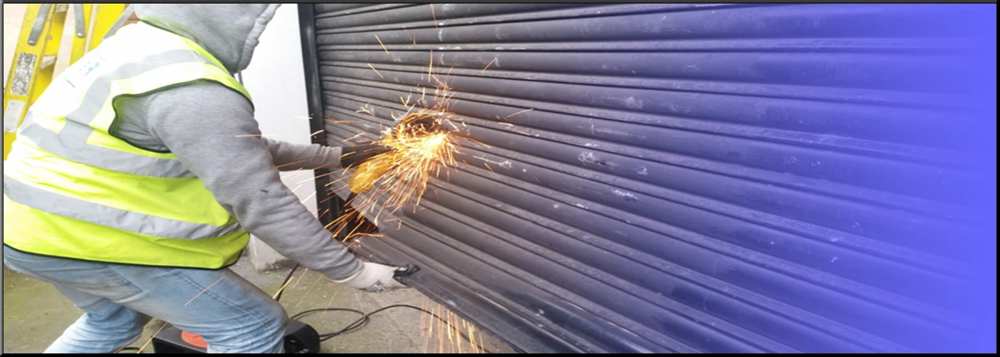 Expert technician meticulously repairing a commercial roller shutter mechanism in Dover